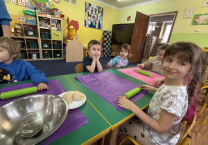 Dzieci siedzą przy stolikach.