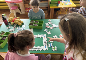 Dzieci przy stolikach kodują drogę ozobota.