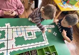 Dzieci przy stolikach kodują drogę ozobota.