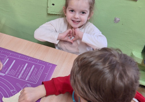 Chłopiec przy stole zwija rogalki.