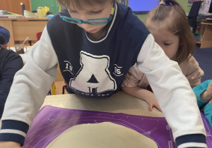 Chłopiec stole dziewczynka wałkuje ciasto.