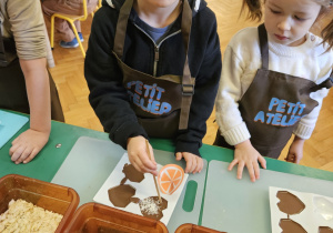 Chłopiec wkłada do czekolady dodatki.