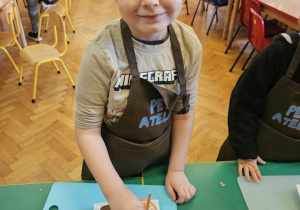 Chłopiec wkłada do czekolady dodatki.