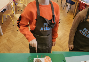 Chłopiec wkłada do czekolady dodatki.