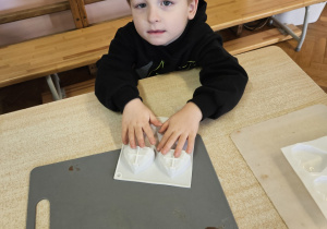 Chłopiec siedzi przy stole.