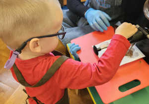 Chłopiec napełnia formy czekoladą.