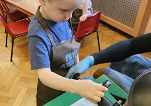 Chłopiec napełnia formy czekoladą.