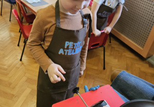 Chłopiec napełnia formy czekoladą.