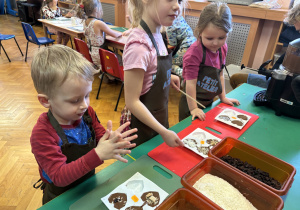 Dzieci wkładają do czekolady dodatki.