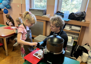 Dziewczynka wypełnia formy czekoladą.