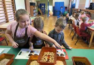 Dzieci wkładają do czekolady dodatki.