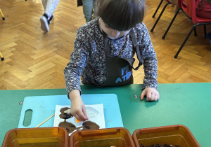 Dziewczynka wkłada do czekolady dodatki.