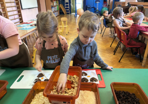 Dzieci wkładają do czekolady dodatki.