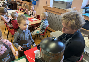 Chłopiec wypełnia formy czekoladą.