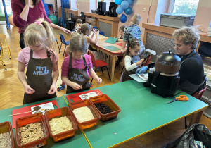 Dziewczynki wkładają do czekolady dodatki.