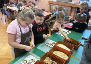 Dzieci wkładają do czekolady dodatki.