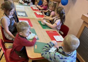 Dzieci siedzą przy stole.