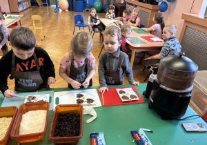 Dzieci wkładają do czekolady dodatki.