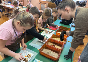 Dzieci wkładają do czekolady dodatki.