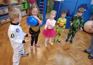 dzieci w przebraniach bawią się na balu karnawałowym