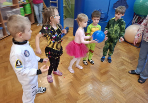 dzieci w przebraniach bawią się na balu karnawałowym