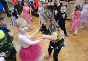 dzieci w przebraniach bawią się na balu karnawałowym