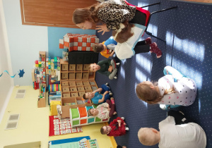 dzieci przygladają się skunksowi w brązowym kolorze, który siedzi na kolanach pani