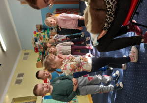 dziewczynka głaszcze skunksa, który siedzi na kolanach pani