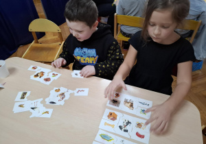 chłopiec i dziewczynka siedzą przy stoliku i układają puzzle edukacyjne