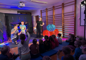 Na scenie chłopiec porusza robotem.