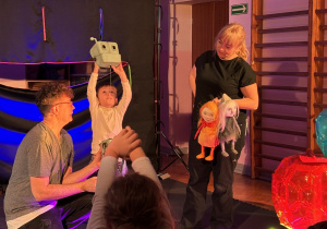 Na scenie dziewczynka porusza robotem.