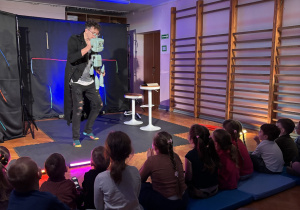 Aktor na scenie z robotem.