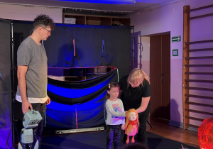 Dziewczynka wraz z aktorami na scenie.