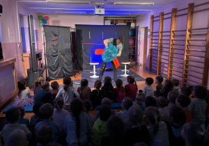 Dzieci siedzą i obserwują widownię.