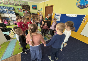 Dzieci ustawione w kole śpiewają "100 lat".