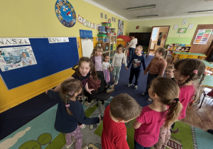 Dzieci ustawione w kole śpiewają "100 lat".