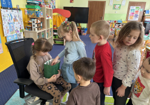 Dzieci ustawione w rzędzie podchodzą do dziewczynki i składają jej życzenia.