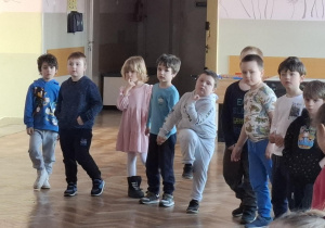 dzieci stoją w kole, bawią się wspólnie z innymi