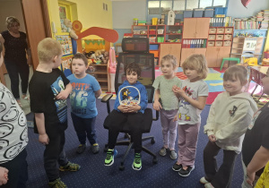 chłopiec świętuje urodziny, dzieci z grupy składaja mu życzenia, chłopiec częstuje cukierkami