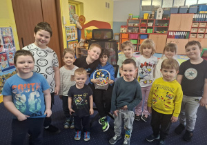 chłopiec świętuje urodziny, dzieci z grupy składaja mu życzenia, chłopiec częstuje cukierkami