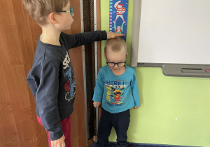 Dzieci mierzą swoją wysokość.