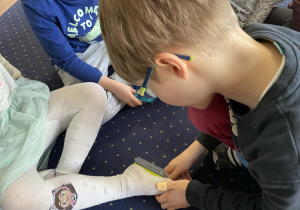 Chłopiec mierzy długość stopy koleżanki.