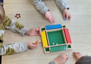 Przy stole dzieci grają w grę.