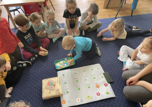 Na dywanie dzieci doskonalą umiejętność dodawania.