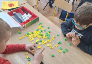 Przy stoliku chłopcy grają w grę.