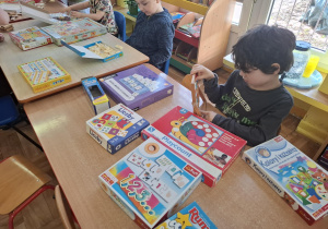 dzieci przy stolikach grają w różne matematyczne gry