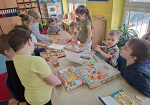 dzieci przy stolikach grają w różne matematyczne gry