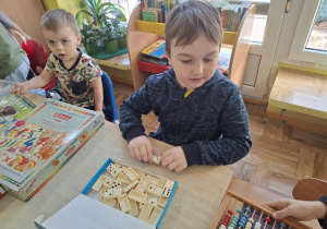 dzieci przy stolikach grają w różne matematyczne gry