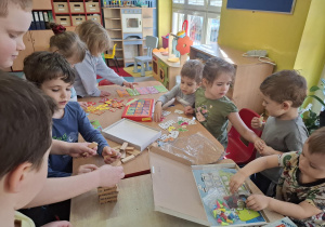 dzieci przy stolikach grają w różne matematyczne gry