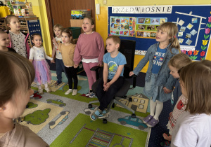 Dzieci ustawione w kole śpiewają "100 lat".